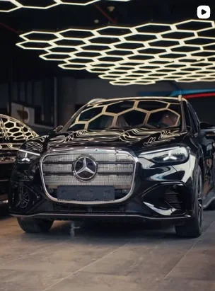 Black Mercedes-Benz SUV under the showroom's hexagon lights